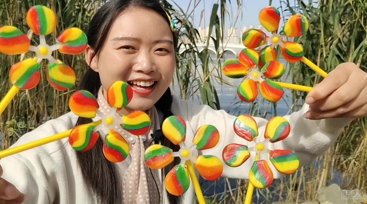 小姐姐吃趣味零食“彩虹风车棒棒糖”，吹不动舔着转，香甜果味浓
